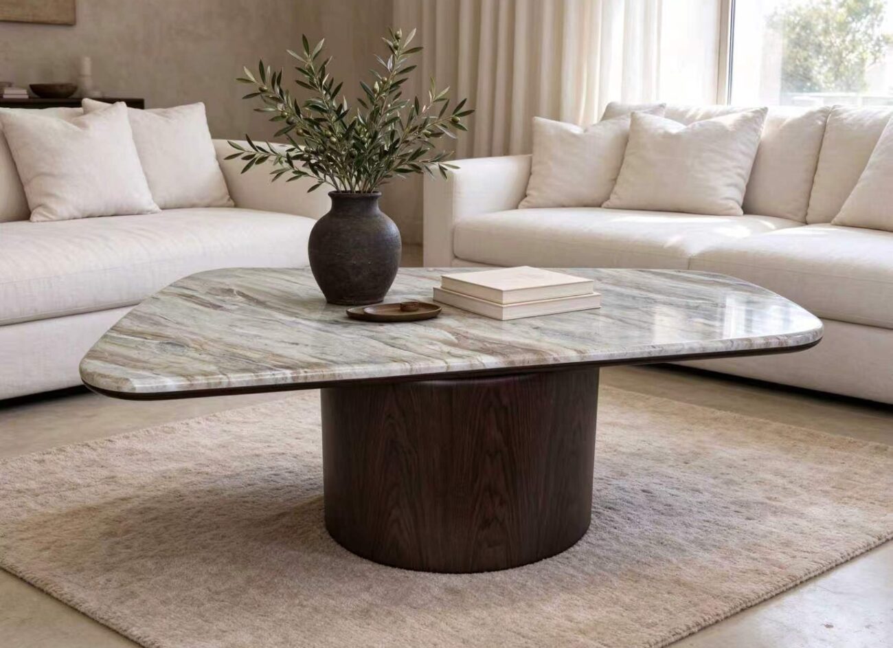 Modern organic marble coffee table with a polished veined marble top and a dark cylindrical solid wood base, styled in a quiet-luxury living room
